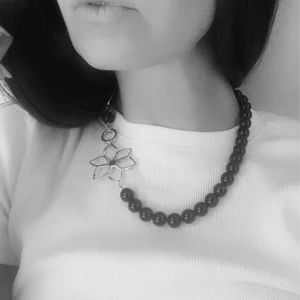 Collier asymétrique MARYLENE perles noires et fleur dorée